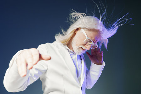 Elderly scientist with white hair in a lab coat, striking a dynamic pose against a gradient blue background, creating a lively and innovative atmosphereの写真素材