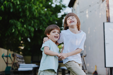 Happy boys playing together in a sunny garden, enjoying their carefree childhood moments and filled with laughter and joy in a vibrant outdoor setting.の写真素材