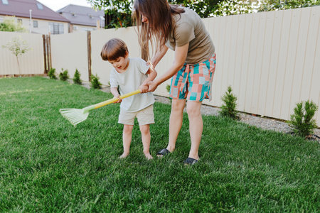 Loving woman playing with her child in the garden, enjoying outdoor activities, and creating joyful memories together in a bright, sunny environment.の写真素材