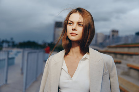 Confident businesswoman in a tailored coat, exuding poise and determination against a contemporary urban backdrop, embodying professionalism and style.の写真素材