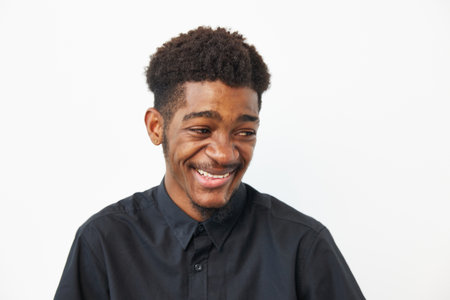 A joyful black man smiling, wearing a stylish black shirt. His expression radiates positivity and confidence, perfect for diverse projects and campaigns.の写真素材