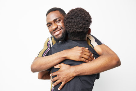 A joyful black man hugging a child, radiating warmth and love. Ideal for family, affection, and bonding themes in visual storytelling.の写真素材