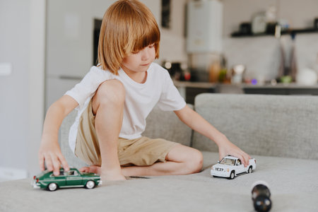 Young boy playing with toy cars in a modern living room, showcasing creativity and imagination in a cozy environment.の写真素材
