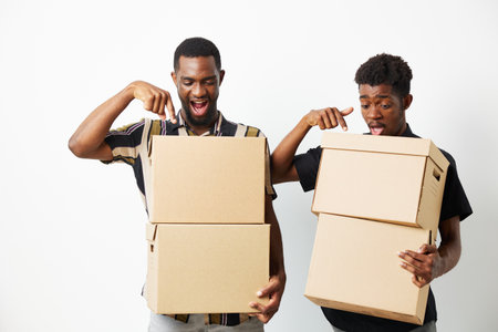 Excited black men unpacking boxes, showcasing surprise and joy. Two friends sharing a moment...