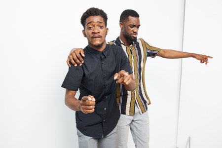 Two joyful black men dancing together in a bright studio, showcasing a lively atmosphere and...