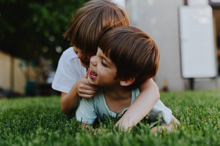 Happy children playing together, enjoying laughter on a sunny day in a green grass field, capturing the essence of childhood joy and friendship.の写真素材