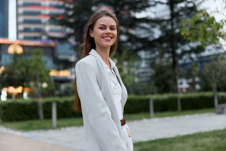 Confident woman in white jacket smiling outdoors urban background business concept professional young adultの写真素材