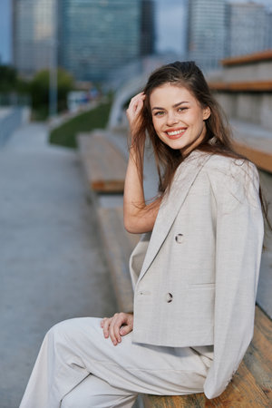 smiling woman in beige business suit outdoors urban background casual confident young adultの写真素材