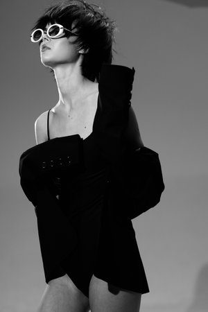 black and white woman wearing sunglasses and stylish jacket with short hair looking confident and...