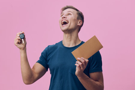 cheerful man holding car key and envelope excited look pink background digital detox concept freedom...