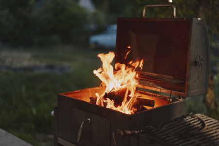 Warm glow of flames in a barbecue grill, creating a cozy outdoor atmosphere, perfect for summer...