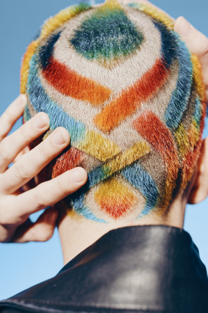 Woman with colorful geometric hair design shaved head, creative style, vibrant pattern, close-up,...