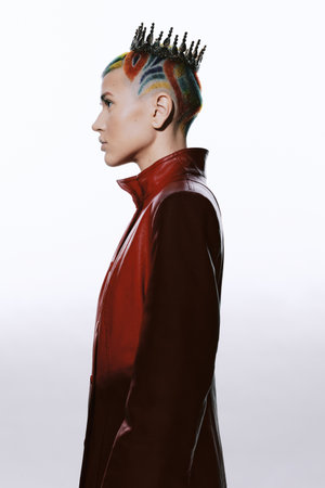 profile of a woman with colorful braided hair wearing a red leather jacket and a unique hair crown,...