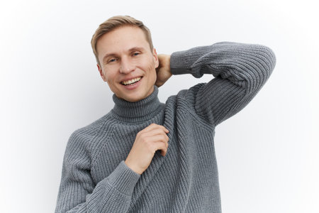 Smiling man, casual gray sweater, cheerful expression, modern hairstyle, light background,...