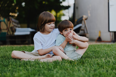 Happy children enjoying a sunny day, playing together on the grass, showing joy and connection in...