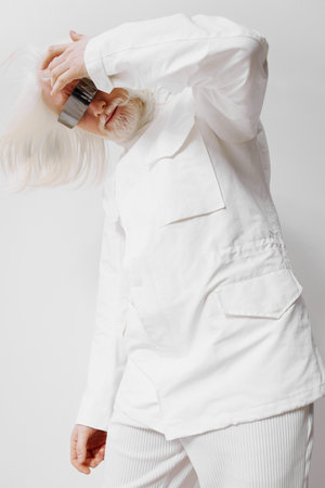 elderly man in white outfit, artistic portrait, playful pose, white background, creative expression, stylish fashion, unique hair, candid shot, contemporary style, deep emotionsの写真素材