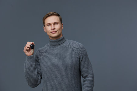 Young caucasian man wearing gray knitted turtleneck smiling confident isolated on gray background...