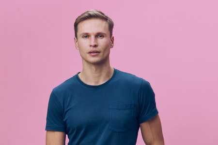 Full body shot of a young Caucasian man with short light brown hair wearing a casual blue t-shirt,...