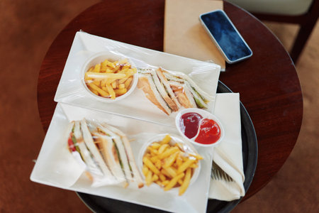 Tasty sandwich platter with French fries served in a modern caf setting, highlighting delicious fast...
