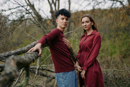 A couple stands outdoors in soft autumn light, conveying genuine connection and authenticity through...