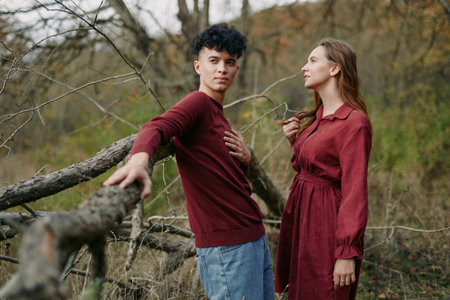 Young couple posed outdoors in natural woodland, sharing a genuine connection and subtle gestures that convey authenticity and credibility in candid, lifestyle portrait photography.の写真素材