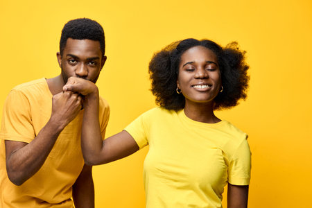 Smiling couple in matching yellow outfits against a vibrant yellow background, showcasing love and joy Bright colors emphasize their happiness and connectionの写真素材
