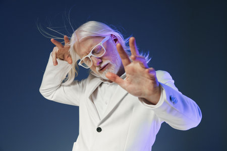 elderly man in white suit, stylish glasses, dancing, expressive pose, modern vibe, whimsical background, gray and blue colors, joyful energy, dynamic movement, unique fashion conceptの写真素材