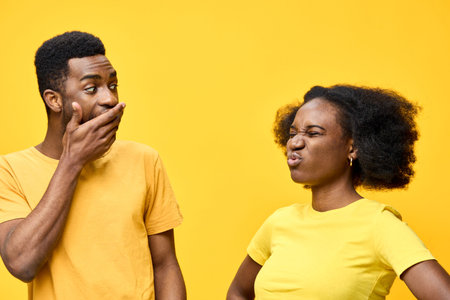 A couple expressing playful emotions against a vibrant yellow background, showcasing dynamic interactions and diverse expressions in matching yellow outfitsの写真素材