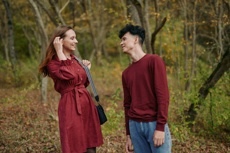 An intimate candid moment captures a natural connection between two people in a sunlit autumn park, conveying authenticity and credibility through relaxed posture, warm facial expressions, andの写真素材