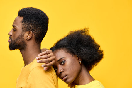 Young couple in vibrant yellow attire against a bright yellow background, showcasing love and connection, emphasizing emotional intimacy and cultural representationの写真素材