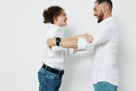 A man shares a confident, joyful moment with a colleague, hands joined in a friendly handshake, highlighting emotion and teamwork against an isolated colored background.の写真素材