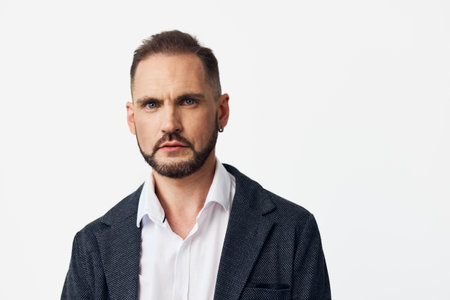 A professional businessman stands before an isolated colored backdrop, exuding calm confidence and leadership, with a focused expression that conveys executive poise and reliability.の写真素材