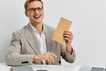 Smiling young man coding work laptop mobile phone business casual office digital nomad concept technology freelance remote workの写真素材