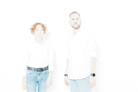 A confident professional man stands on a colored isolated background, exuding calm focus and keen intent. The scene conveys business knowhow and steady leadership through posture and gaze.の写真素材