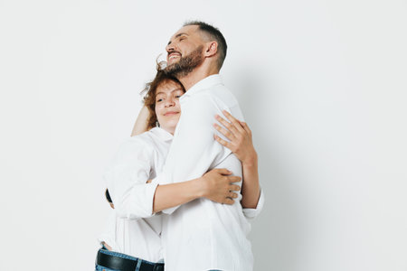 Professional man in business attire shares a warm hug, expressing trust, leadership, and success emotions, portrayed against an isolated soft color backdrop.の写真素材