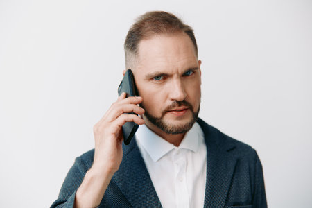 A focused business man on an isolated color background exudes confidence, intensity, and determination through a firm gaze and posture, signaling a professional mood of strategic decision making andの写真素材