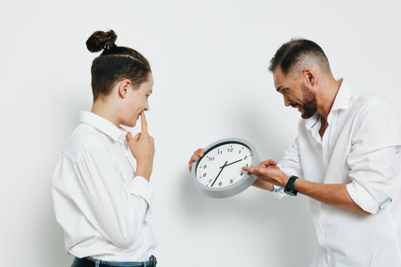A professional man and a younger colleague stand in a bright, isolated colorful background, sharing...