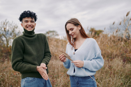 Authentic moment in a natural field captures two people sharing a candid exchange, showcasing real expression and simple style that convey credibility and warmth.の写真素材