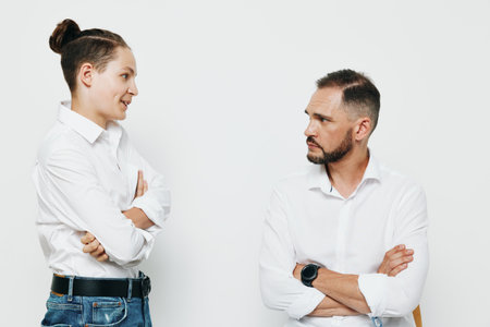 A professional man and colleague stand with arms crossed, showing confident and thoughtful emotions against an isolated color background.の写真素材