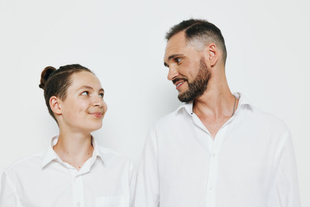 A professional man in business attire shares a warm smile with a colleague on an isolated white...
