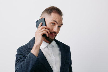 Professional man on a phone, business mood, confident and focused, posing against an isolated colored background. Expresses determination and calm, ready for a strategic call.の写真素材