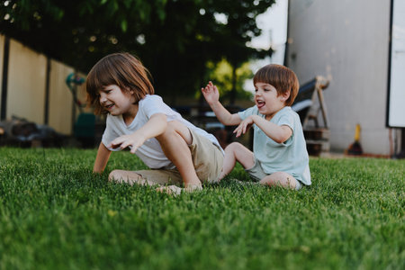 Playful children enjoying a sunny day in the garden, capturing the essence of childhood joy and laughter, surrounded by greenery and bright sunlight.の写真素材
