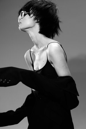 Stylish woman with short hair wearing sunglasses in black and white monochrome fashion pose.の写真素材