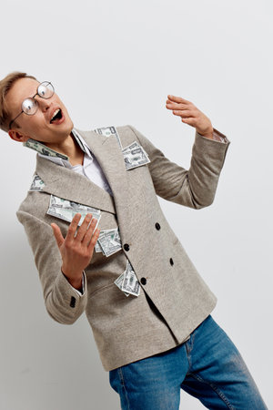 excited man with money bills in blazer casual wear expressive happy young caucasian businessman standing isolated on plain white background finance conceptの写真素材