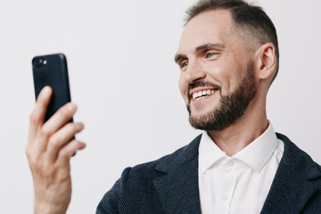 A confident business professional takes a selfie against a solid colored background, showcasing approachable charm, modern work life, and a positive, ready-to-connect mindset.の写真素材