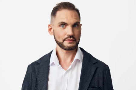 A business professional man stands against a bright colored background, exuding confidence and focus, portraying a poised, executive mood suitable for corporate portrait and marketing use.の写真素材