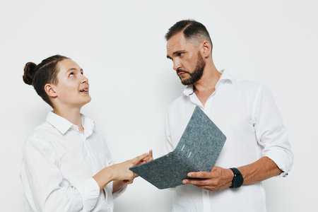 A professional business man with focused expression reviews documents against a vibrant, isolated colorful background, conveying confidence, calm leadership, and strategic poise.の写真素材