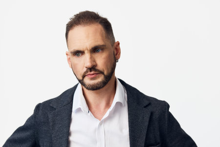 A professional man in business attire stands against an isolated colored backdrop, conveying confident emotion and focus. The subject projects leadership, determination, and calm poise for corporateの写真素材