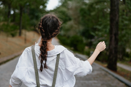 Young woman in casual white outfit walking outdoors, showcasing a relaxed vibe with a sense of...