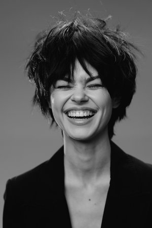 smiling woman with short hair laughing joyfully in black and white portrait, happy expression, natural beauty, casual styleの写真素材